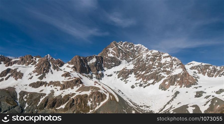 Winter landscape of snow mountain range and blue sky. Scenery background for mountain activities such as skiing, trekking, winter sport and mountain climbing.