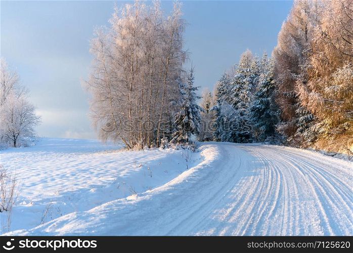 Winter landscape - snow covered mountain road on a cold and sunny morning