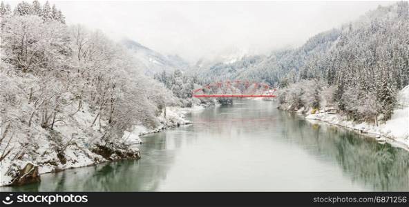 winter landscape with Red Bridge along Tadami River in Fukushima Japan Panorama