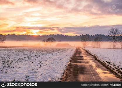 Winter landscape with road, white fields cover by snow and sunset sky.. Winter landscape with road, white fields