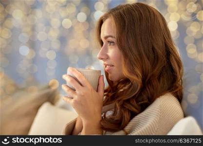 winter, leisure and people concept - happy young woman with cup of coffee or tea in bed at home bedroom. happy woman with cup of coffee in bed at home