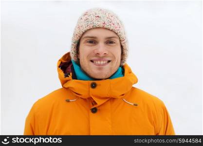 winter, leisure, clothing and people concept - happy teenage boy or young man in winter clothes outdoors