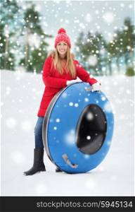winter, leisure, sport, and people concept - happy teenage girl or woman with snow tube outdoors