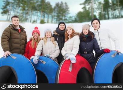 winter, leisure, sport, friendship and people concept - group of smiling friends with snow tubes outdoors
