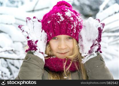winter - little happy smiling girl outdoors at the snowfall time