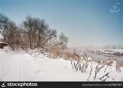 Winter misty river. Snow and frost. Snowy road. Overcast snowy weather. Cloudy cold January day.