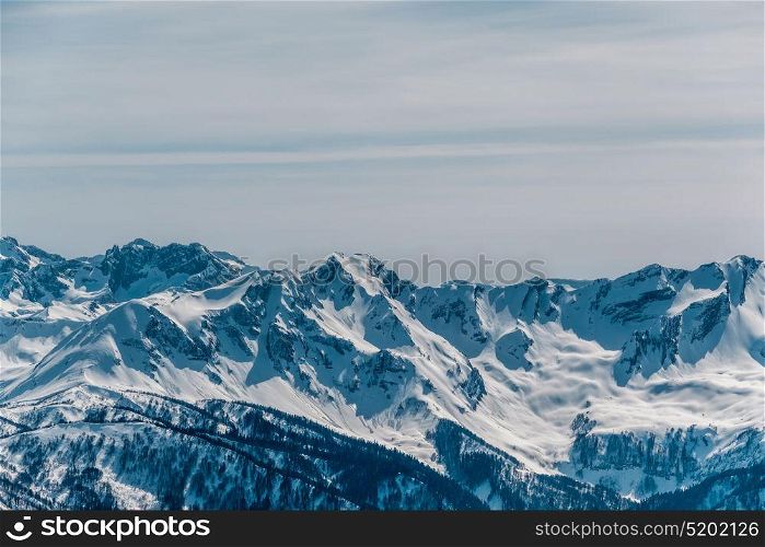 Winter mountain landscape. Caucasus ridge covered with snow in sunny day. Krasnaya Polyana, Sochi, Russia