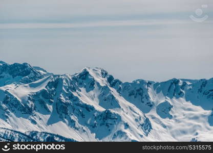 Winter mountain landscape. Caucasus ridge covered with snow in sunny day. Krasnaya Polyana, Sochi, Russia