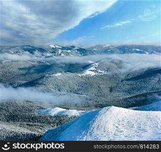 Winter mountain landscape with low-hanging clouds. View from the mount top (Carpathian, Ukraine).