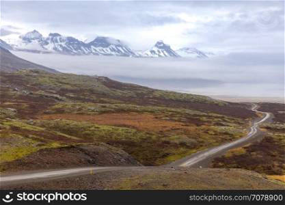Winter Mountain range and gravel road in Oxi Road Iceland