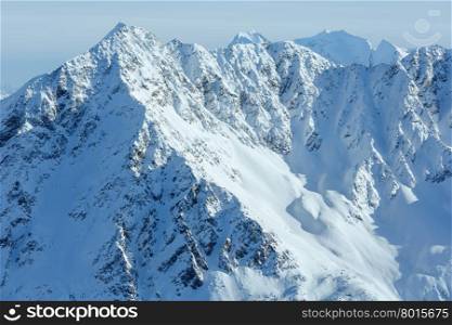 Winter mountain scenery with cross on rock top (Tyrol, Austria).