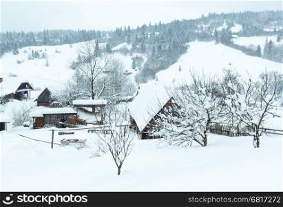 Winter mountain village. Country Ukrainian Carpathians landscape in misty weather.