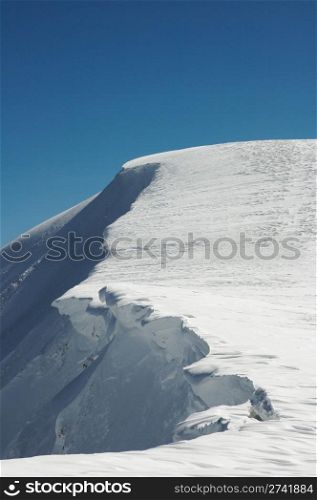 Winter mountain with overhang snow caps on blue sky background (Ukraine, Carpathian Mt&rsquo;s, Svydovets Range, Blyznycja Mount, Drahobrat ski resort)
