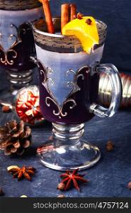 Winter mulled wine. Christmas mulled wine with an orange slice in stylish wineglass