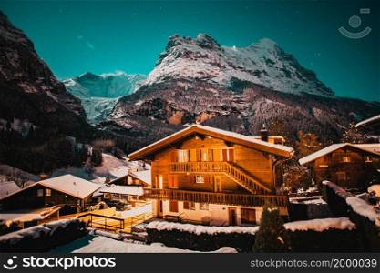 winter night Grindelwald snowy mountain, stars and wooden house