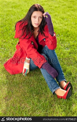 Winter outfit portrait of beautiful female model sitting green grass