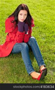 Winter outfit portrait of beautiful female model sitting green grass
