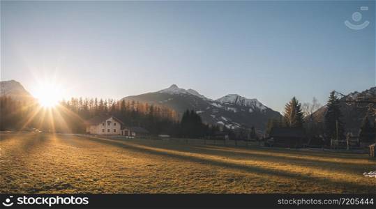 Winter panorama in the Alps mountains. Sunset over alpine village on a December evening, in Ehrwald, Austria. Bright sun over winter alpine scenery