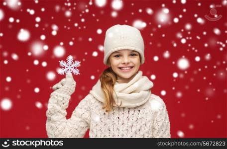 winter, people and happiness concept - smiling girl in hat, scarf and gloves with big snowflake