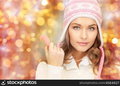 winter, people, christmas and holidays concept - happy smiling woman in hat over lights background