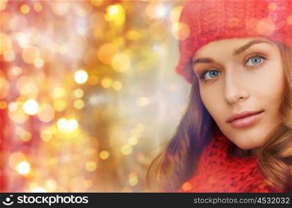 winter, people, christmas and holidays concept - woman in hat and scarf over lights background
