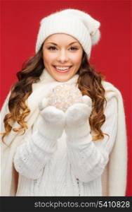 winter, people, happiness concept - happy woman in hat, scarf and mittens with christmas ball