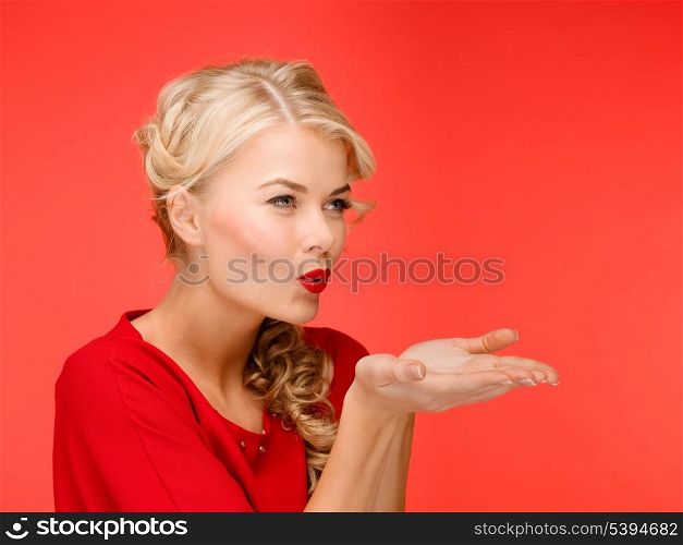 winter, people, happiness concept - happy woman in red dress blowing on palms