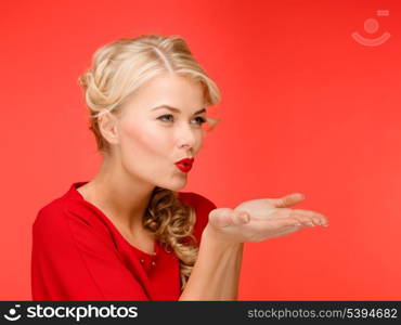 winter, people, happiness concept - happy woman in red dress blowing on palms