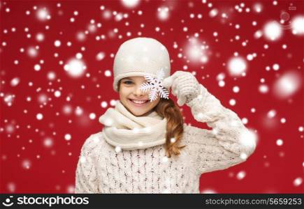 winter, people, happiness concept - smiling girl in hat, muffler and gloves with big snowflake