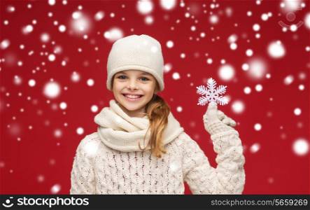 winter, people, happiness concept - smiling girl in hat, muffler and gloves with big snowflake
