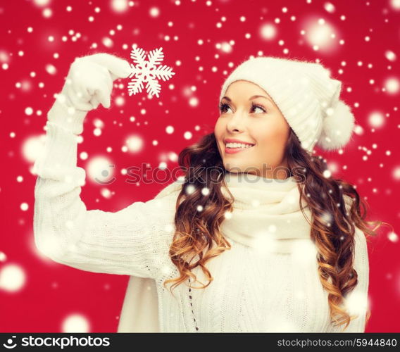 winter, people, happiness concept - woman in hat, muffler and gloves with big snowflake