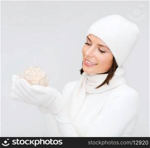winter, people, happiness concept - woman in hat, muffler and gloves with christmas ball