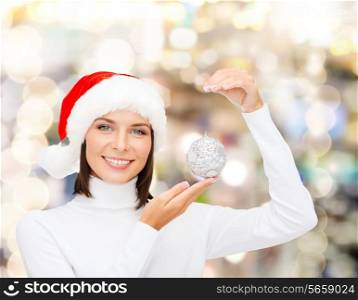 winter, people, happiness concept - woman in santa helper hat with christmas tree decoration over lights background