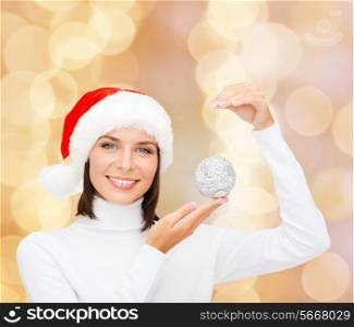 winter, people, happiness concept - woman in santa helper hat with christmas tree decoration over beige lights background
