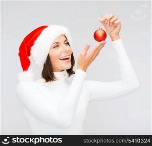 winter, people, happiness concept - woman in santa helper hat with christmas tree decoration ball