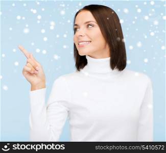 winter, people, happiness concept - woman in white sweater pointing to something