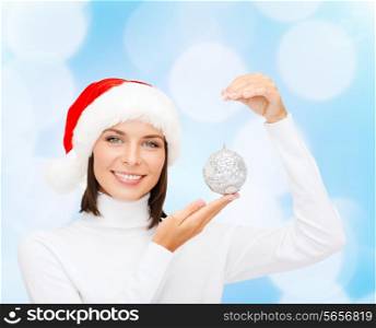 winter, people, happiness, decoration and holidays concept - woman in santa helper hat with christmas tree decoration over blue lights background