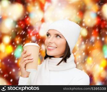 winter, people, happiness, drink and fast food concept - woman in hat with takeaway tea or coffee cup
