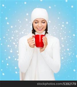 winter, people, happiness, drink and food concept - woman in hat with red tea or coffee mug