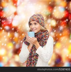 winter, people, happiness, drink and food concept - woman in hat with red tea or coffee mug looking up