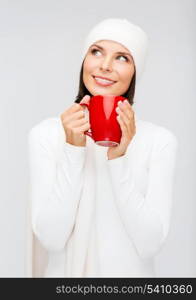 winter, people, happiness, drink and food concept - woman in hat with red tea or coffee mug