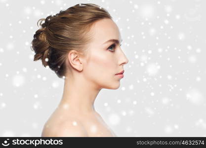 winter, people, plastic surgery and beauty concept - beautiful young woman face over gray background and snow