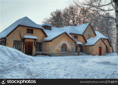 Winter picture of yellow brick house with seven roofs