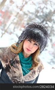 winter portrait of a beautiful blonde dressed in a fur hat