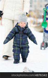 Winter portrait of toddler boy with mother in warm coat outdoors