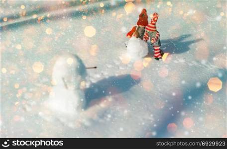 Winter romantic scene of two little wooden men, winter fun when building a snowman
