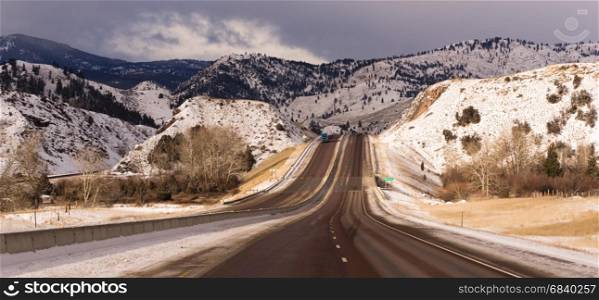 Winter scene with tucks coming and going on icy roads in Utah