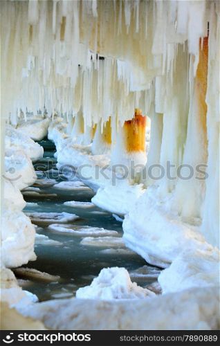 Winter scenery. Close up detail of old pier in Gdynia Orlowo Poland with ice formations icicles. Frozen Sea Baltic covered with snow, seasonal specific.