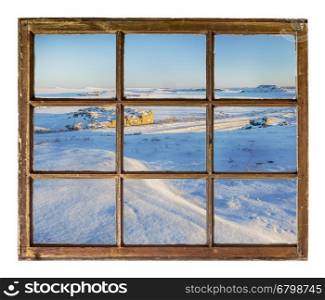 Winter scenery of northern Colorado prairie as seen through vintage, grunge, sash window with dirty glass