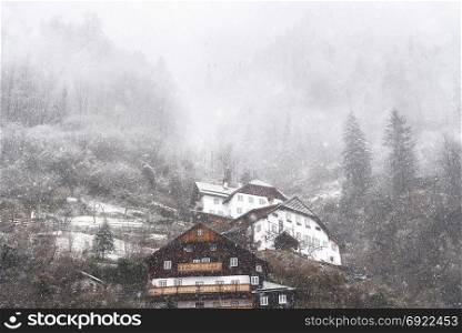 Winter scenery with a dense snowfall over an Austrian village, Hallstatt, located on the Dachstein massif, one of the World Heritage Sites in Austria.